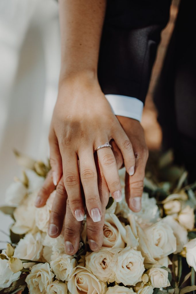 Mains des mariés avec alliances et bouquet de fleurs - Wedding planner Auvergne Rhônes Alpes - Clermont ferrand - Vichy - Lyon - Aurillac